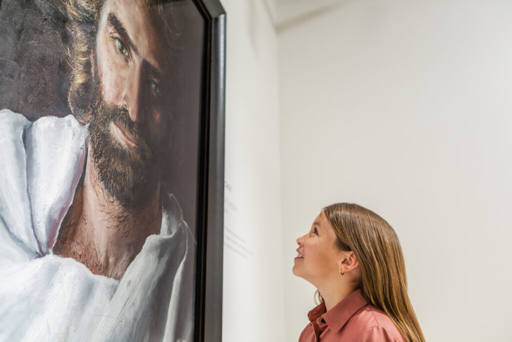 Young girl admiring Akiane Kramarik’s Prince of Peace painting at Beloved Gallery in Marble Falls, Texas.