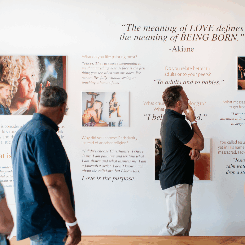 Beloved Gallery visitors looking at the Akiane: The Early Years exhibition looking for opportunities to volunteer