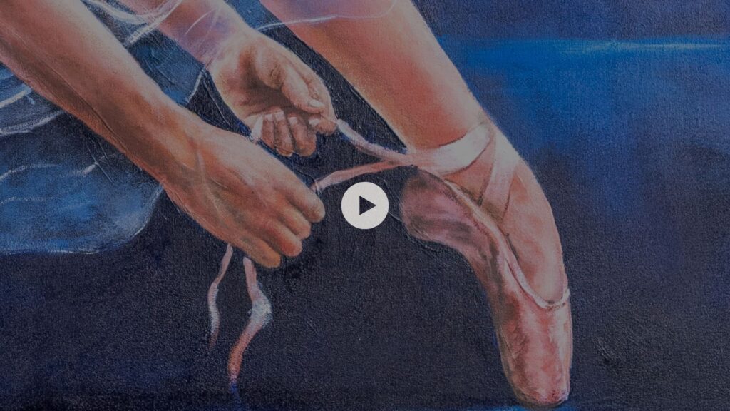 A ballerina tying the ribbons on her pointe shoe.